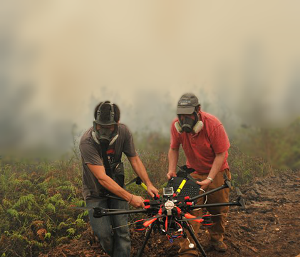 Scientists carrying a UAV away from a wildfire